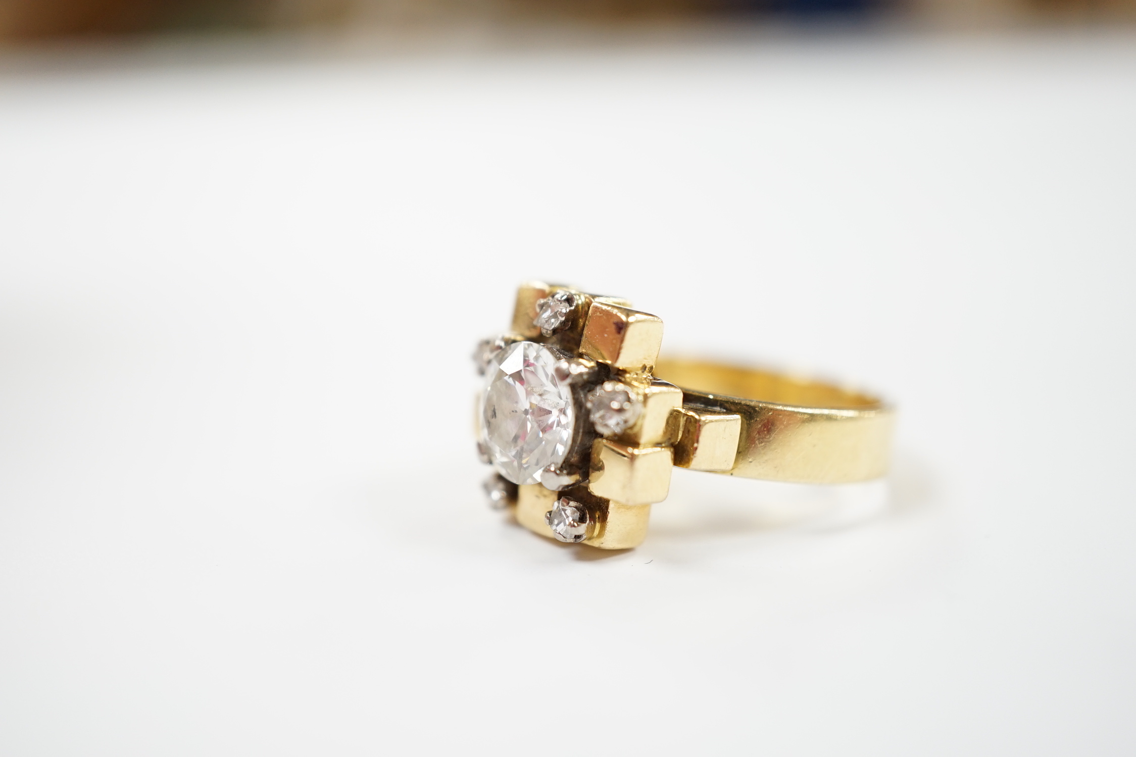 A 1970's 18ct gold and single stone diamond set ring, with five stone diamond mounted setting, size L, gross weight 10.1 grams, the central stone weighing approximately 1.40ct.